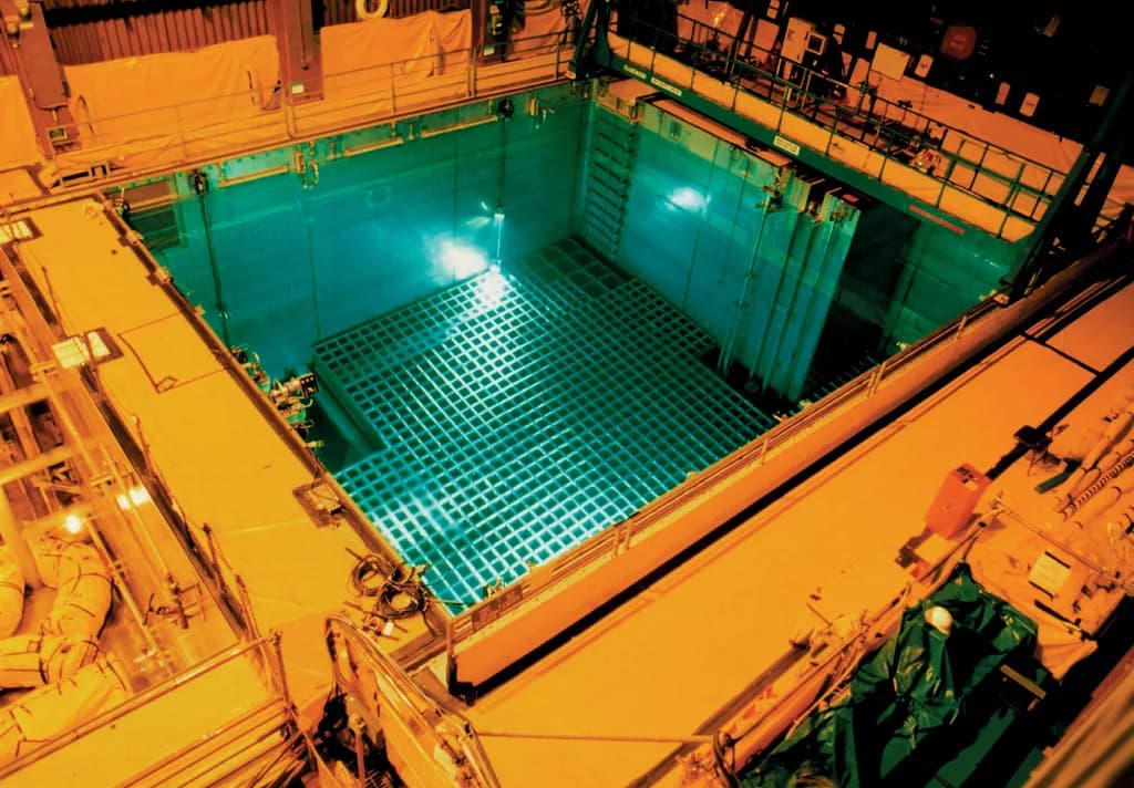 Used nuclear fuel storage pool with blue Cherenkov radiation glow